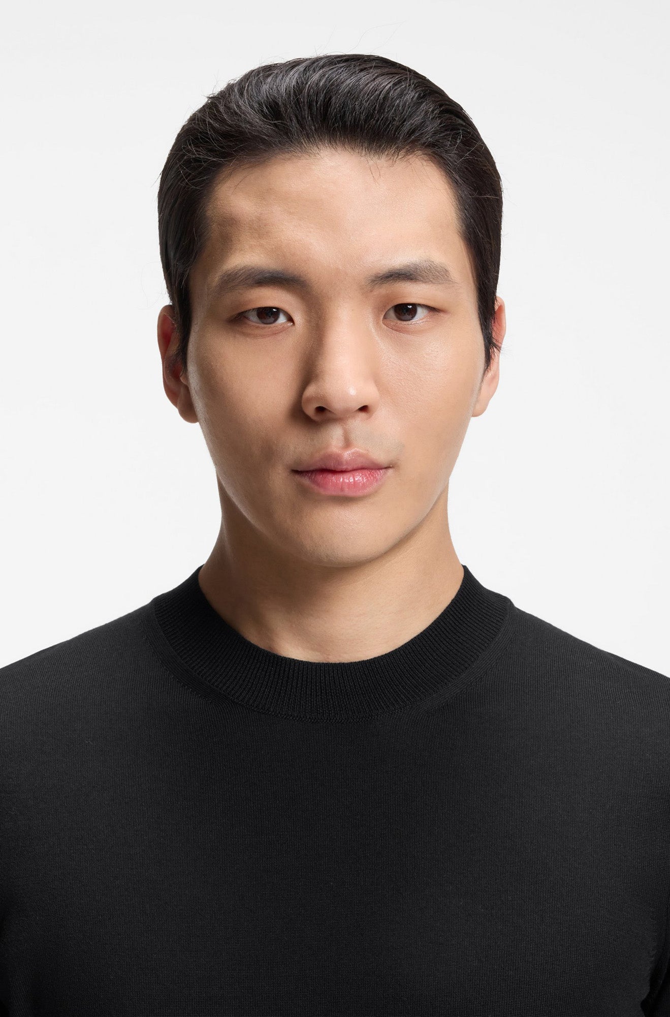 T-Shirt noir en tricot montrant le col rond côtelé et le haut du devant pour homme par HUGO BOSS, en gros plan
