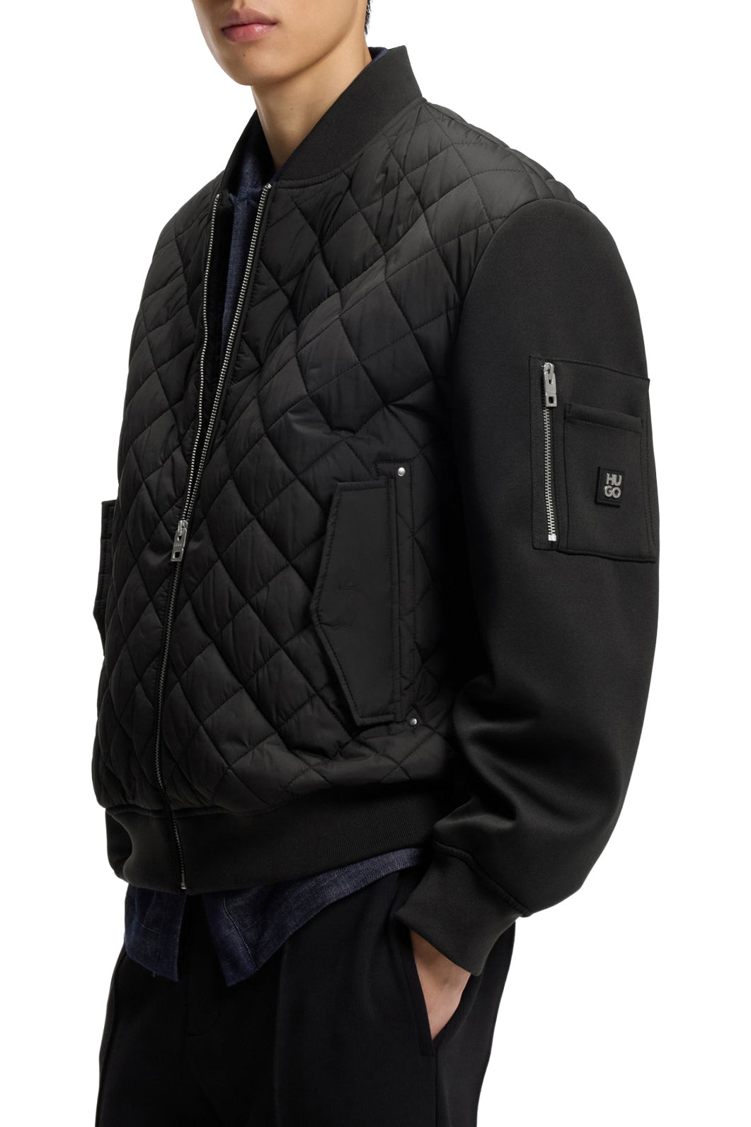 Veste noir matelassée montrant la poche en biais et la poche zippée pour homme par HUGO BOSS, vue de côté