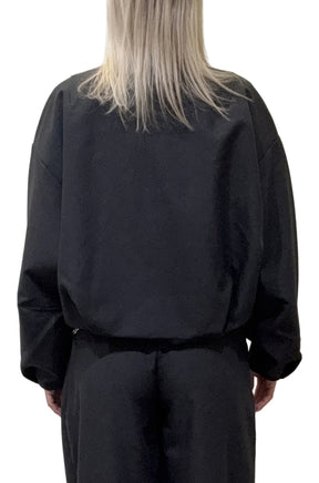 Vue arrière de la veste coupe-vent mi-saison noire, avec manches amples et ourlet court froncé pour femme par HUGO BOSS