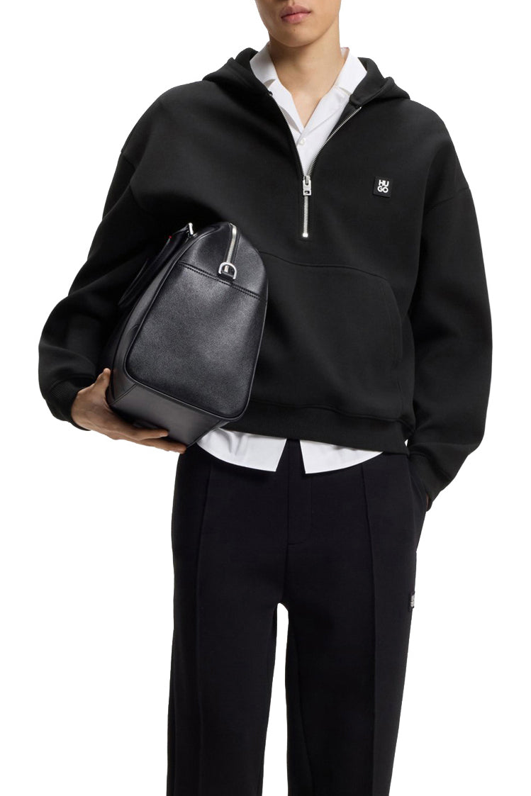 Men's styled front view of black half-zip sweatshirt partly covered by a black bag, with small chest logo by HUGO BOSS