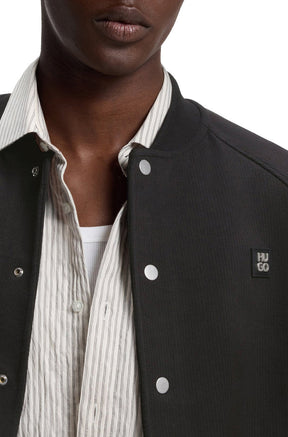 Veste aviateur noir à boutons-pression argent et écusson HUGO à la poitrine pour homme par HUGO BOSS, en gros plan