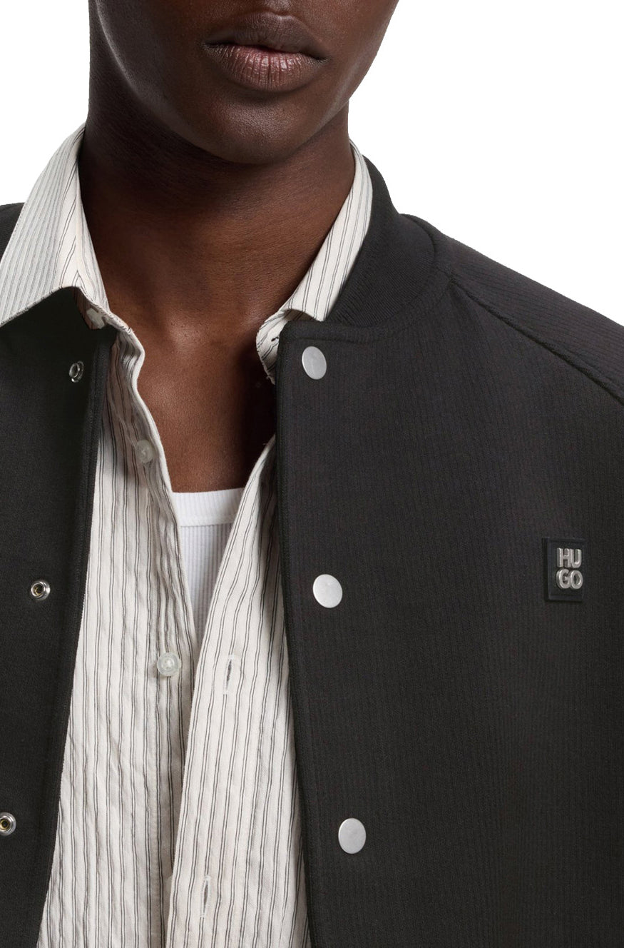 Veste aviateur noir à boutons-pression argent et écusson HUGO à la poitrine pour homme par HUGO BOSS, en gros plan
