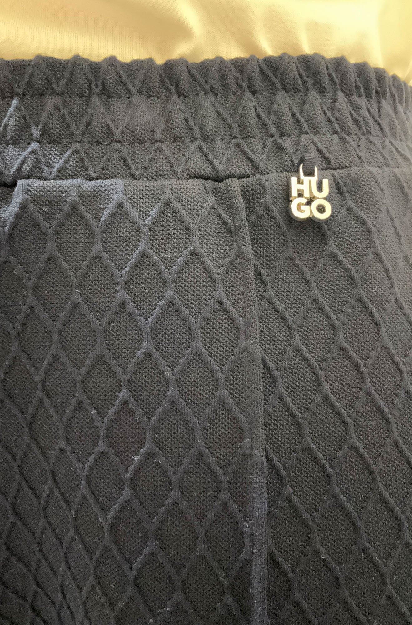 Pantalon jambe large noir texturée avec taille élastique et petit logo HUGO argenté pour femme par HUGO BOSS, en gros plan