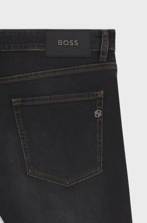 HUGO BOSS men's black straight-leg jeans back pocket with brown stitching, BOSS patch, and metal B trim, close-up