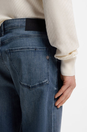 HUGO BOSS men's back model detail of blue washed straight-leg jeans with black waist patch, back pocket and metal B logo