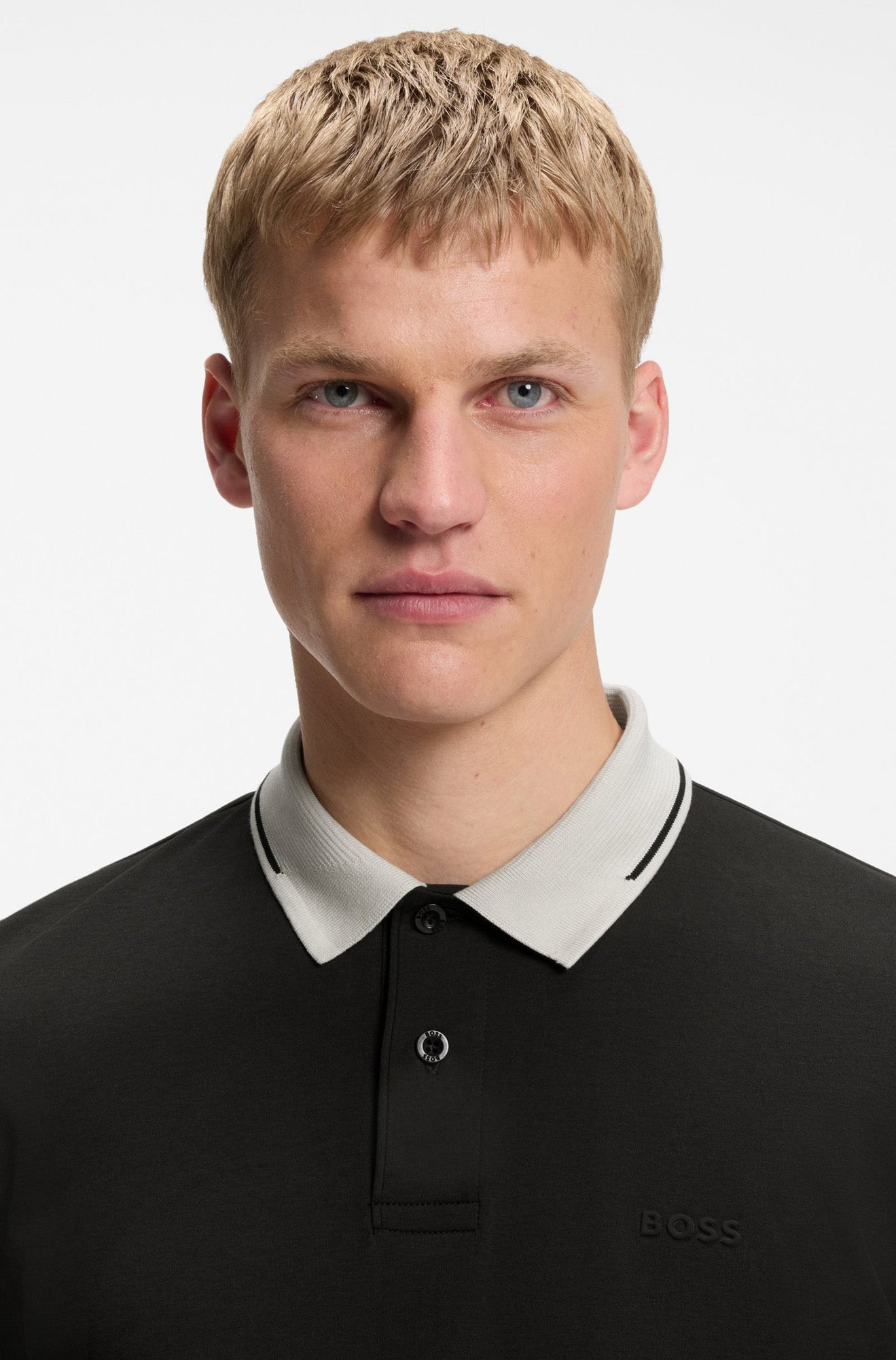 Polo noir avec col côtelé ivoire, patte boutonnée et logo ton sur ton pour homme par HUGO BOSS, en gros plan