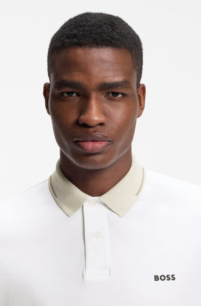 Gros plan du polo blanc montrant le col beige, la patte boutonnée et le logo BOSS pour homme par HUGO BOSS