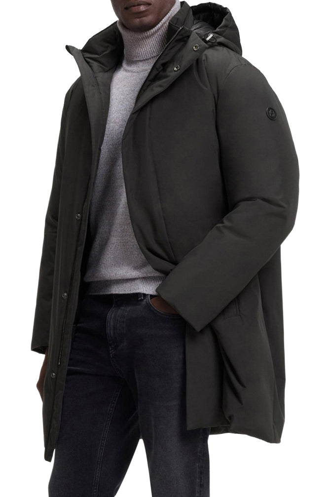 Vue avant en angle du manteau d'hiver noir à capuchon avec patte pressionnée et logo manche pour homme par HUGO BOSS
