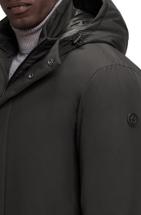 Détail de l'épaule du manteau d'hiver noir avec capuchon à cordon et logo sur la manche pour homme par HUGO BOSS