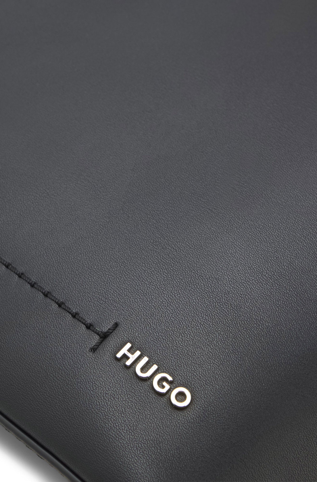 Extérieur du sac noir à grain subtil, couture et petit logo HUGO argenté pour femme par HUGO BOSS, en gros plan