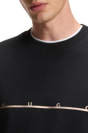 Gros plan du chandail manches longues noir montrant le col rond côtelé et le logo HUGO beige pour homme par HUGO BOSS