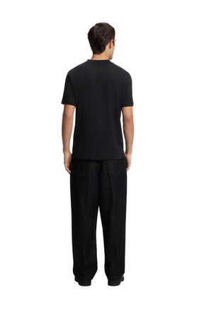 Vue arrière sur mannequin d’un T-Shirt noir uni à manches courtes, col rond et ourlet droit pour homme par HUGO BOSS