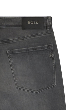HUGO BOSS men's close detail of gray straight-leg jeans back pocket with black BOSS patch and small metal emblem