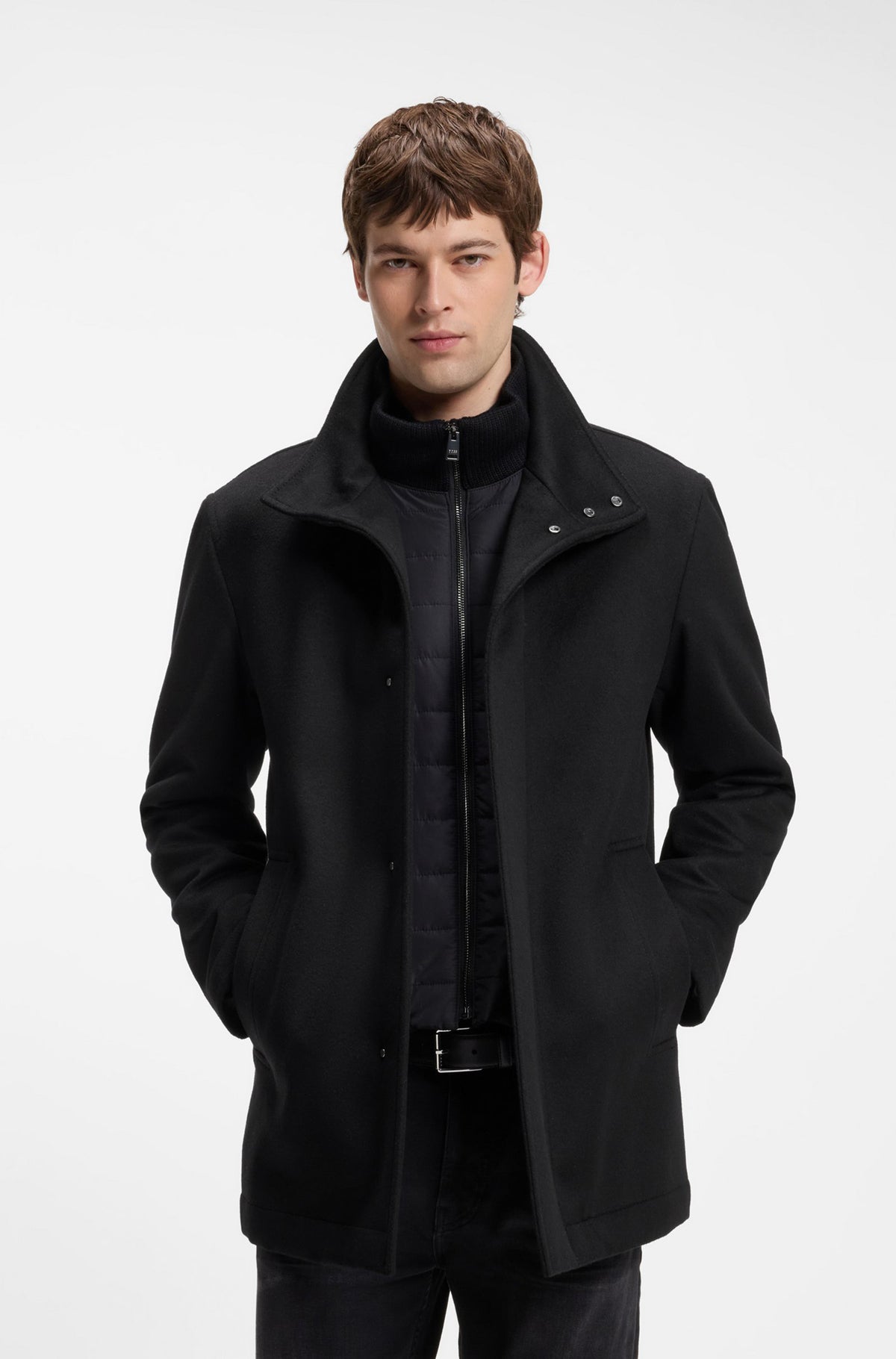 Vue de face d’un manteau d’hiver noir avec col montant, boutons-pression et panneau matelassé pour homme par HUGO BOSS