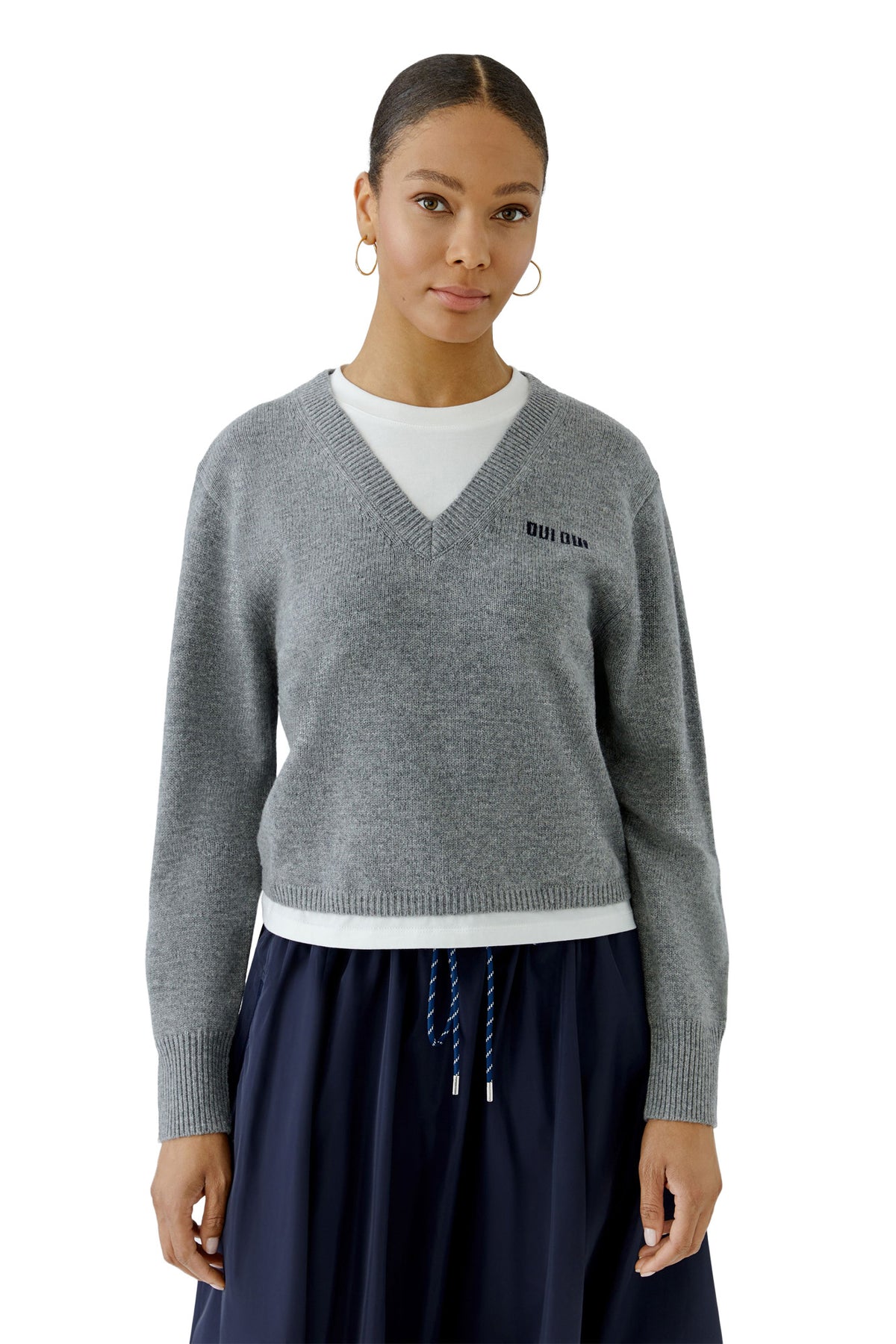 Vue de face mi-corps du chandail manches longues en tricot gris à col en V avec texte noir pour femme par Oui