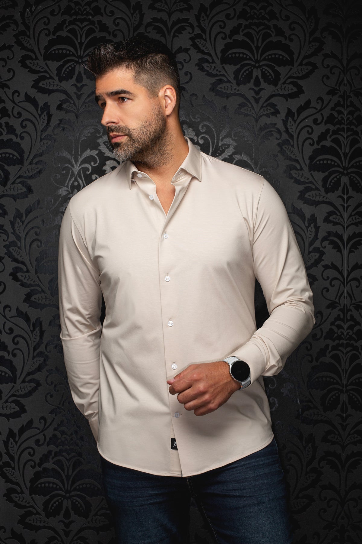 Vue de face d’une chemise beige pâle à manches longues, boutons blancs et col évasé pour homme par Au Noir