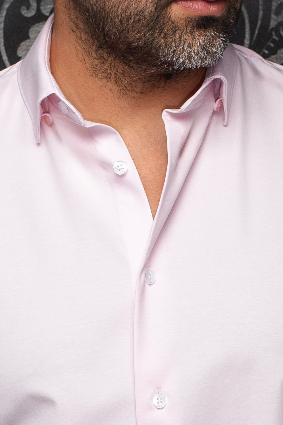 Gros plan du col de chemise rose pâle avec boutons blancs à l'avant et bordure blanche pour homme par Au Noir