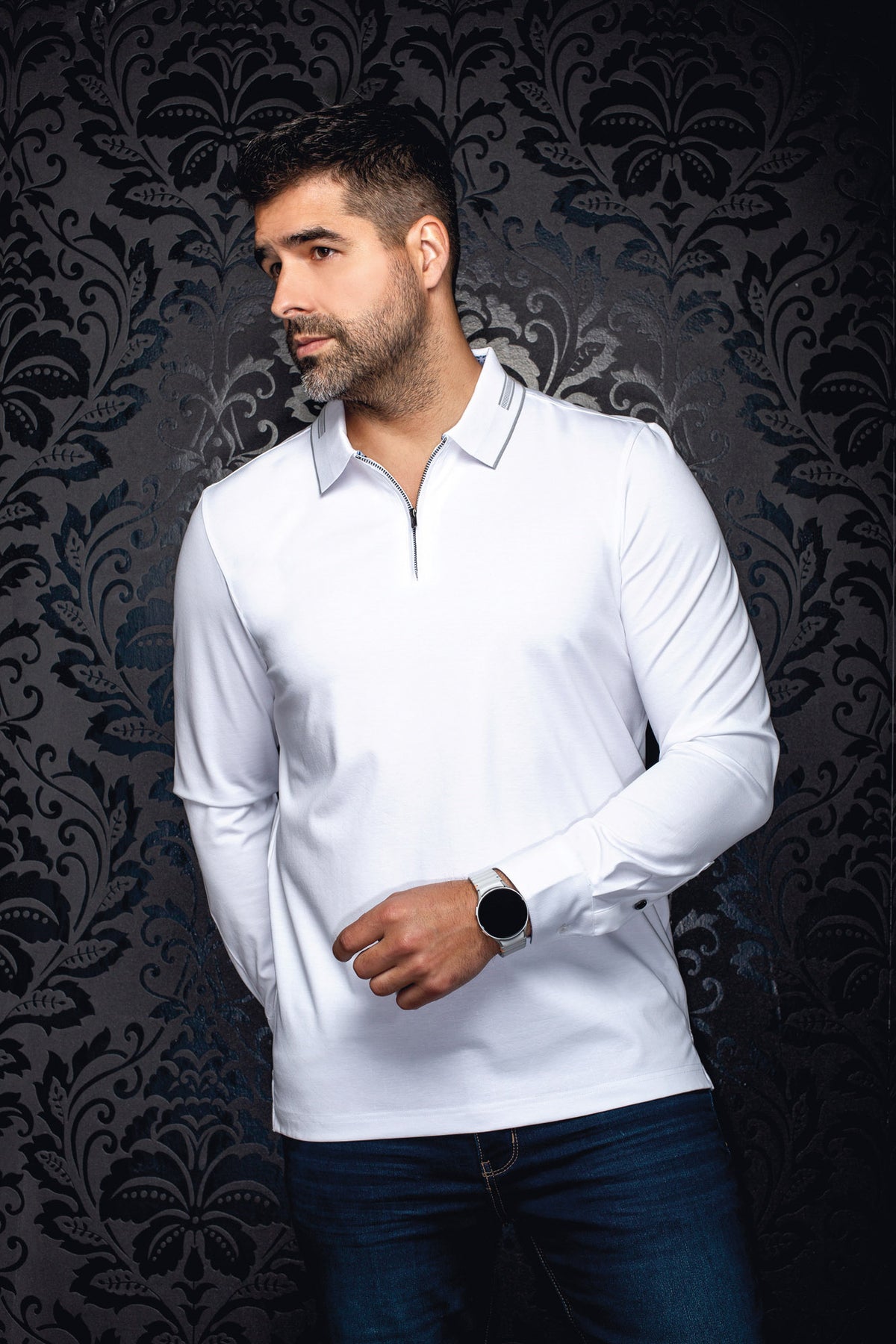 Polo blanc à manches longues avec col à rayures grises et fermeture éclair pour homme par Au Noir, vue de face sur mannequin