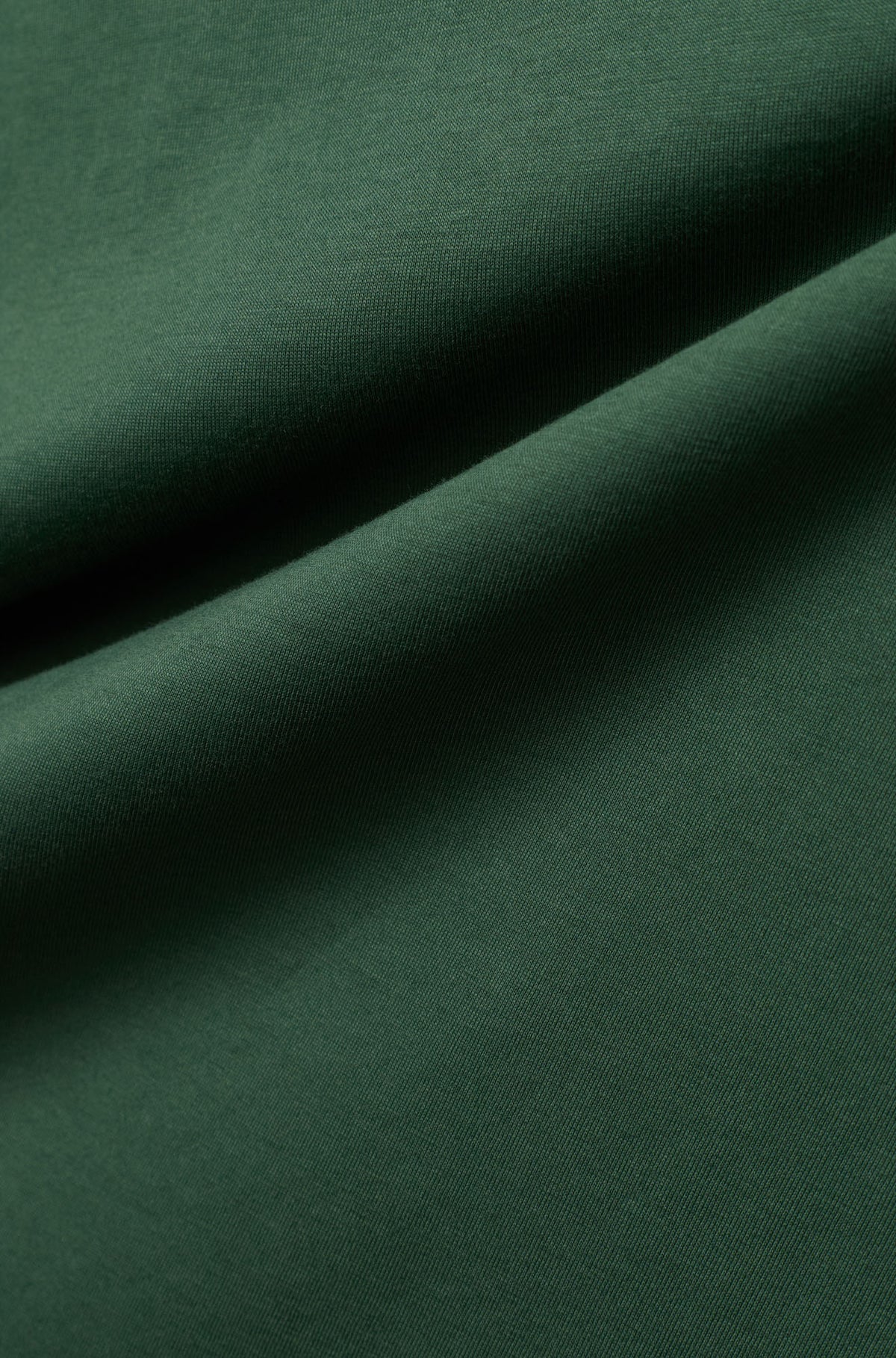 Gros plan du T-Shirt vert foncé montrant jersey et la texture fine du tissu pour homme par Psycho Bunny
