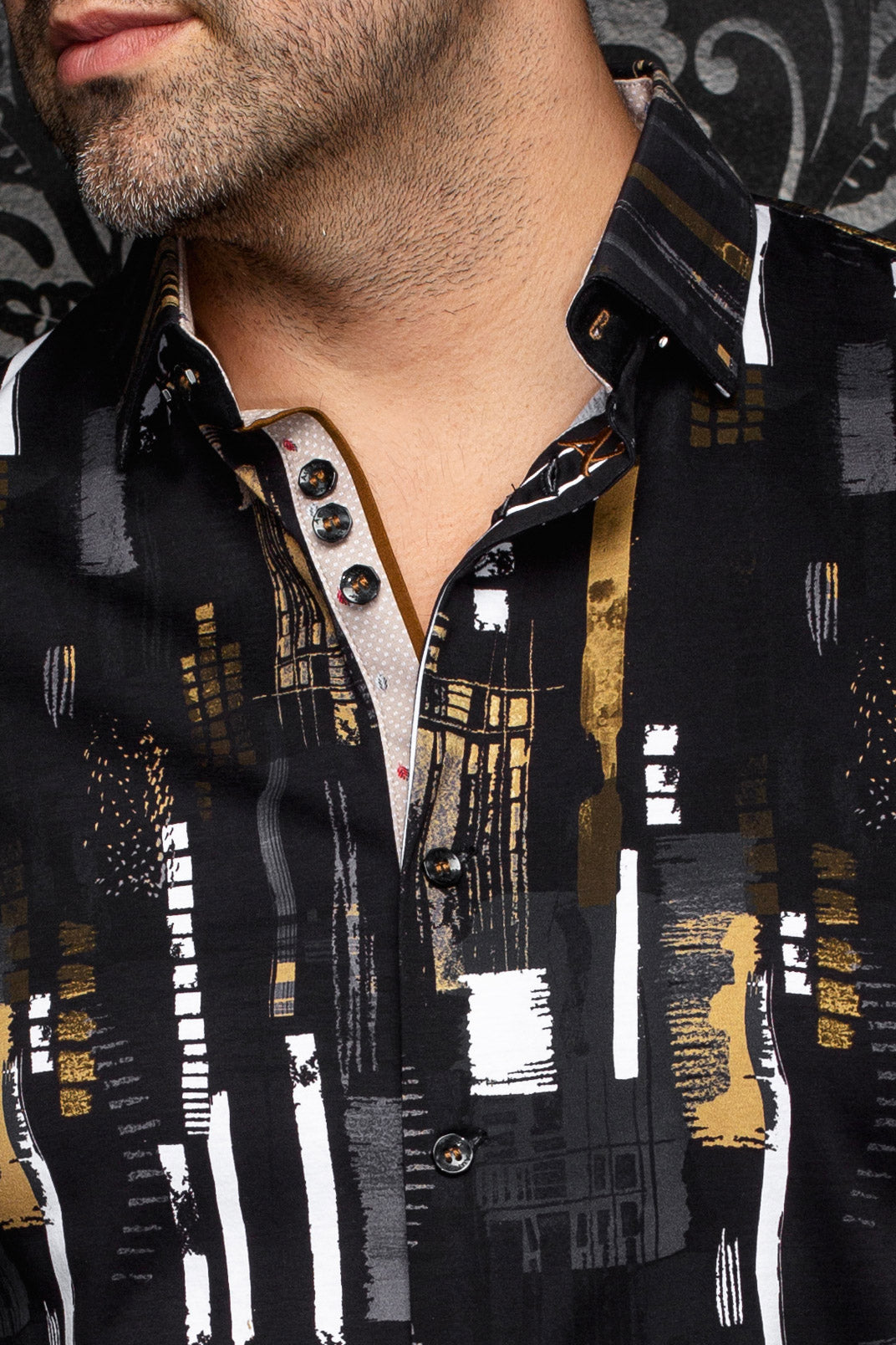 Détail du col d’une chemise noire imprimée avec accents blancs, boutons foncés et patte beige pour homme par Au Noir