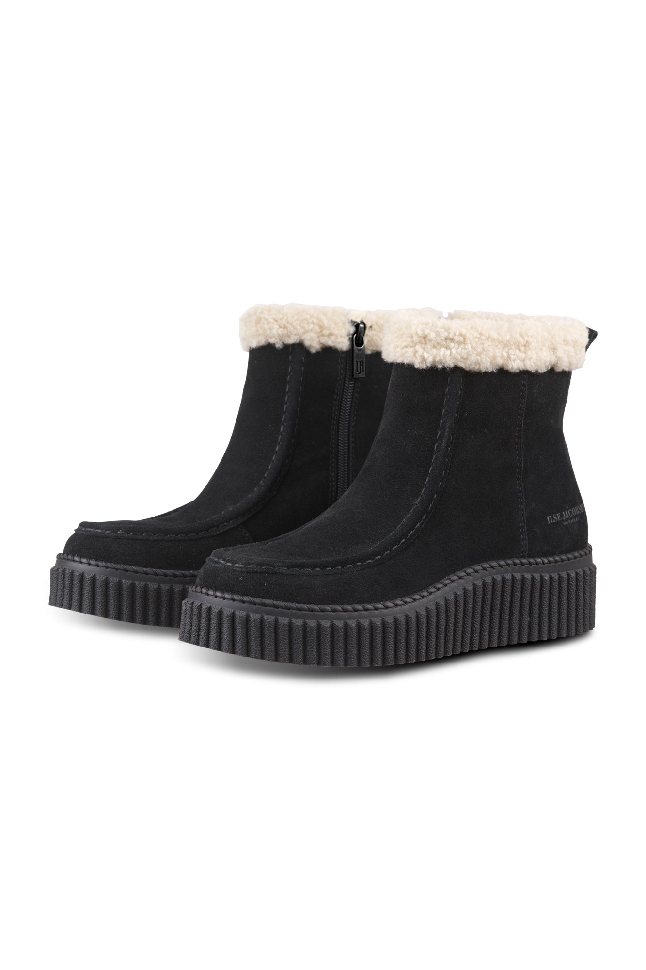Women's black ankle boots angled front view with cream plush cuff, side zipper, and ribbed sole by Ilse Jacobsen