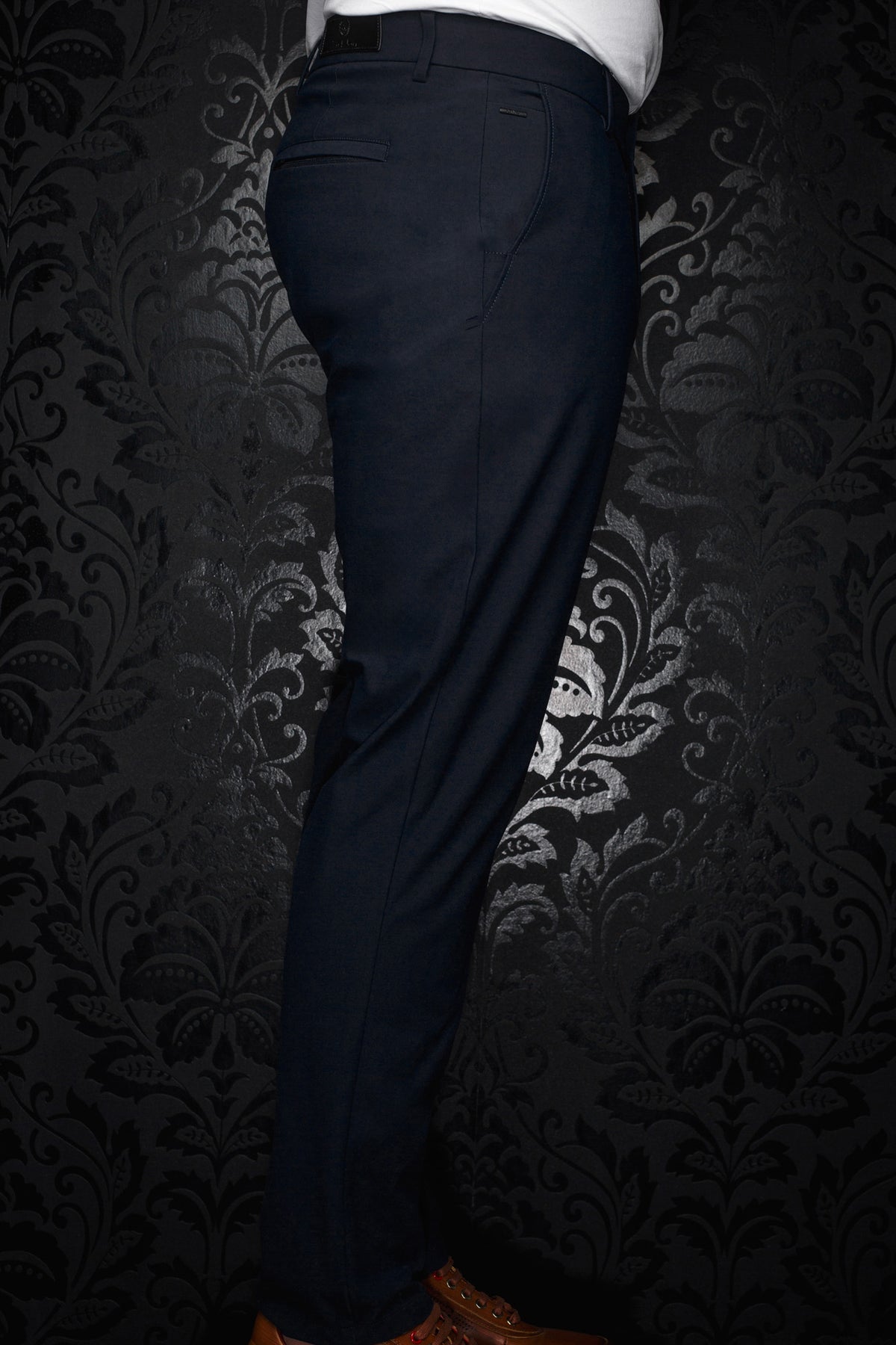 Pantalon bleu marine vu de côté avec petite plaque métal, poche passepoilée et passants pour homme par Au Noir