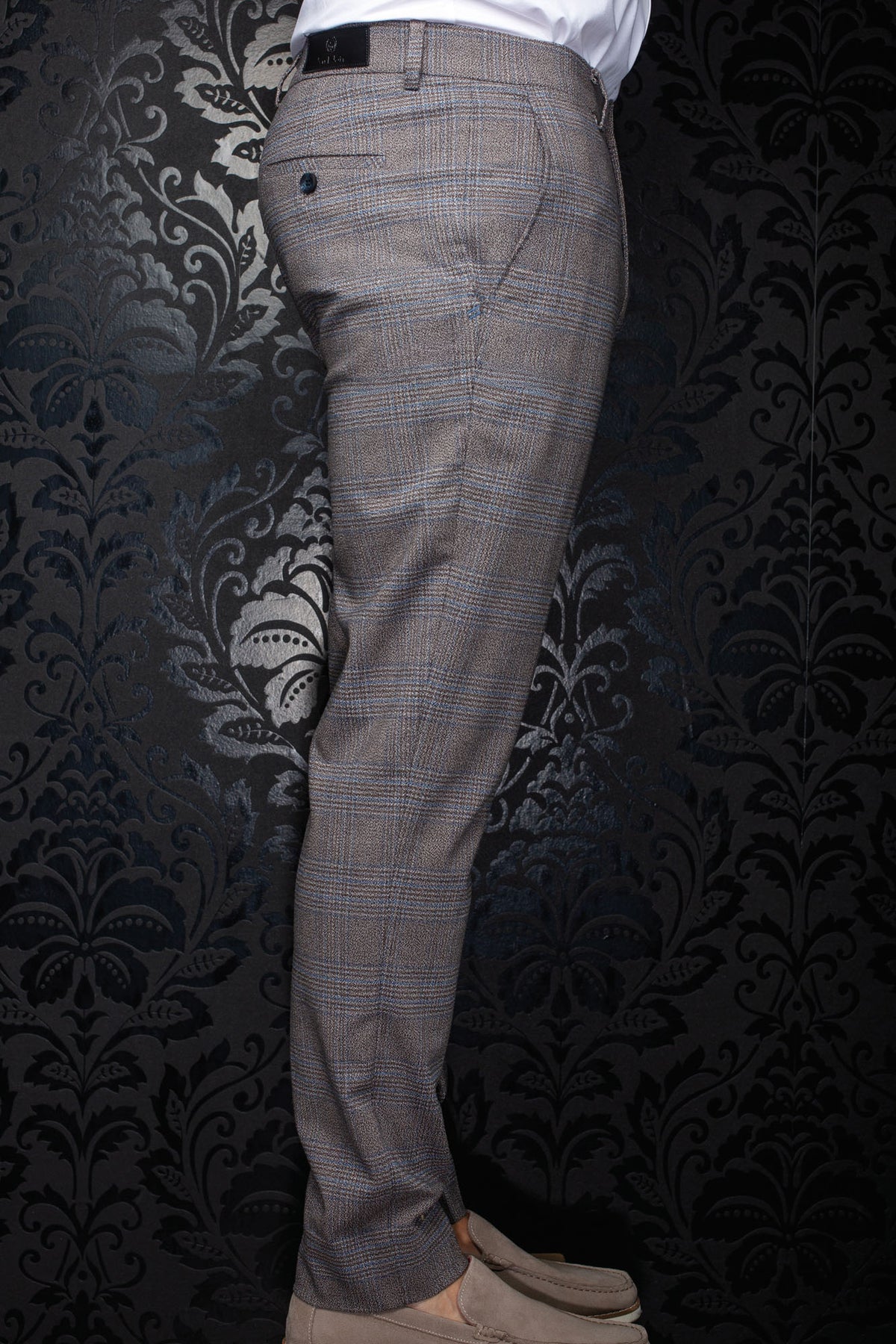 Pantalon à carreaux brun en vue de côté avec étiquette noire et poche arrière boutonnée pour homme par Au Noir