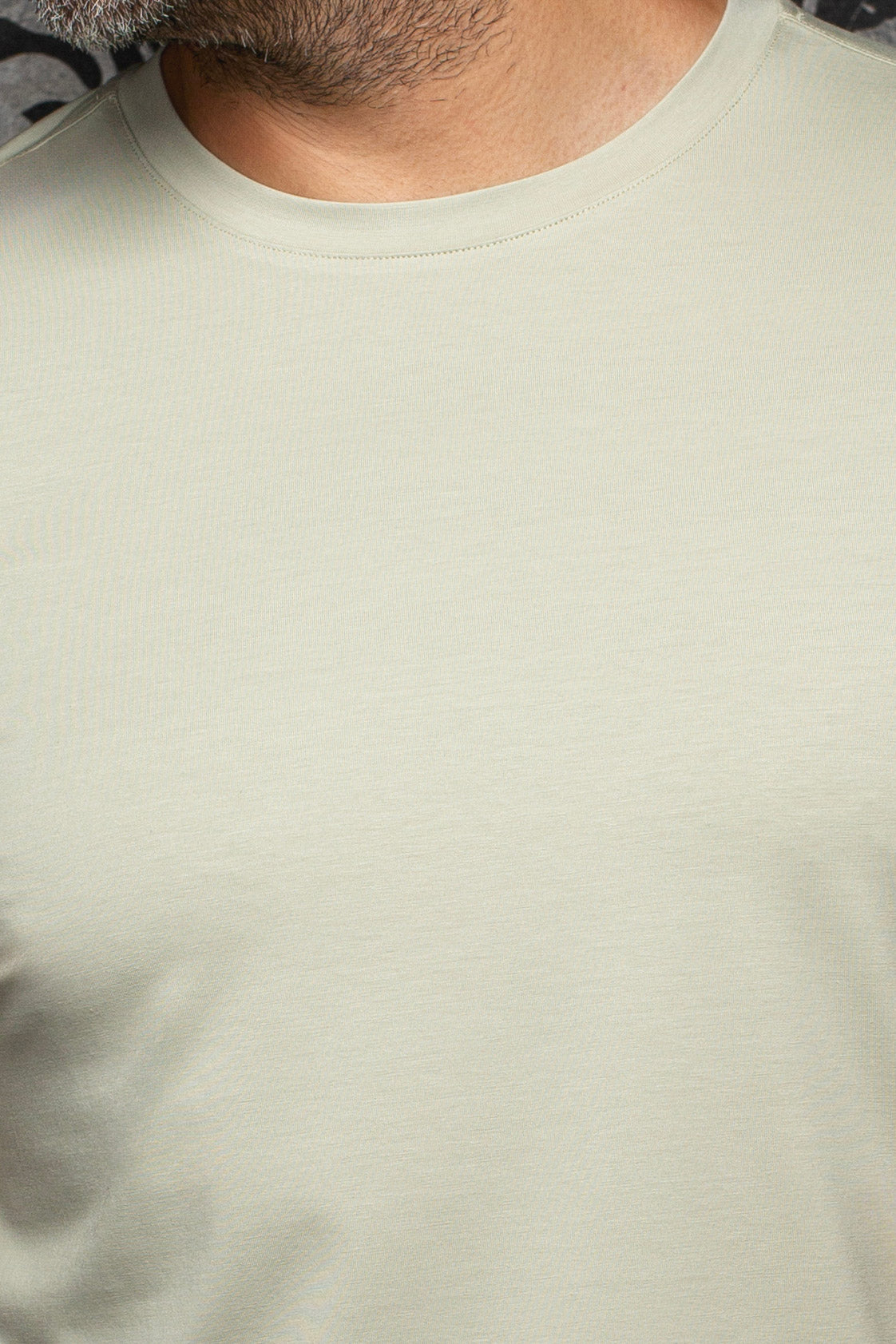 Close-up of fine jersey texture and ribbed collar on Au Noir men's pale sage green crewneck Short-sleeve T-Shirt