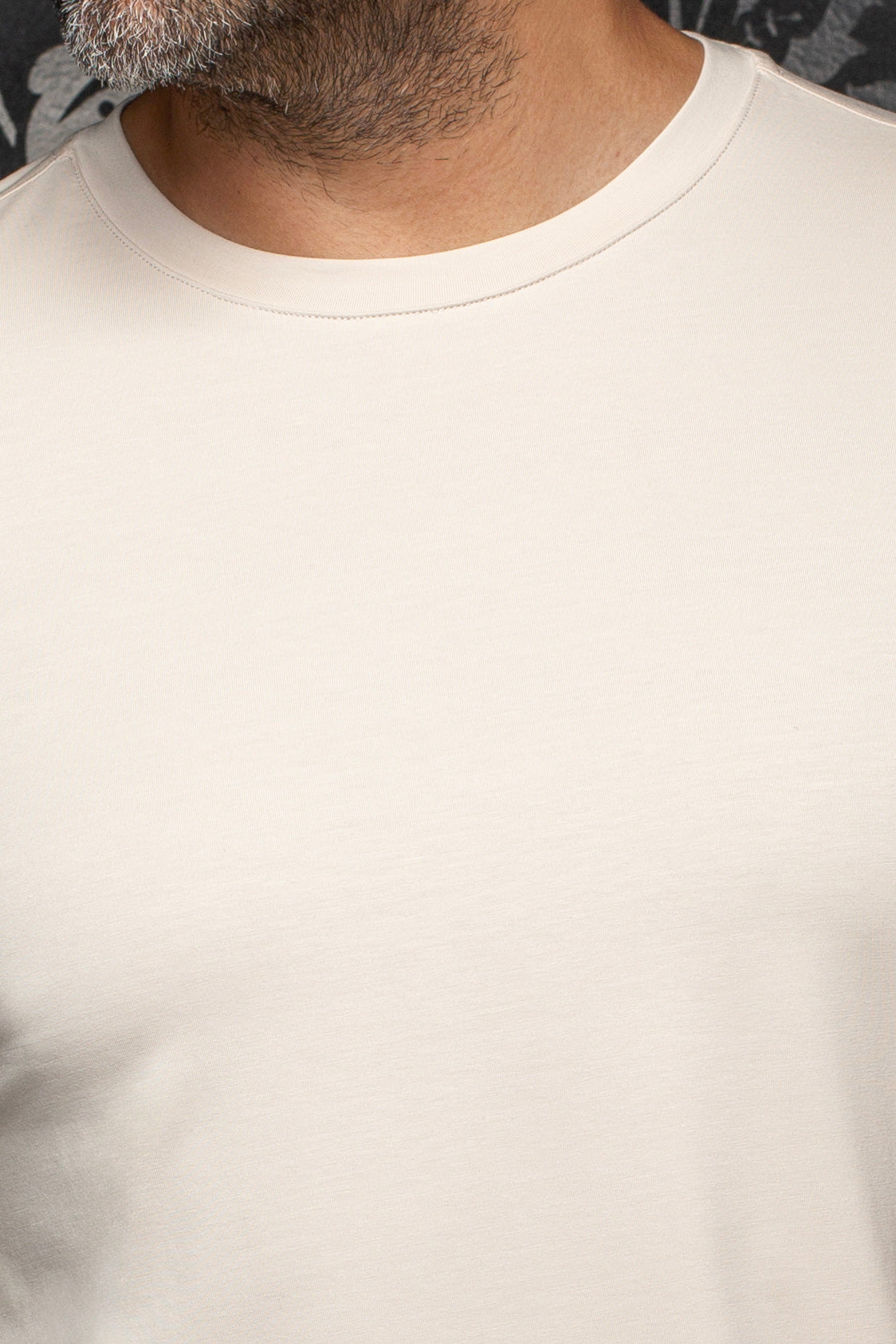 Au Noir men's cream crewneck Short-sleeve T-Shirt collar shown close-up with tonal stitching and smooth knit fabric