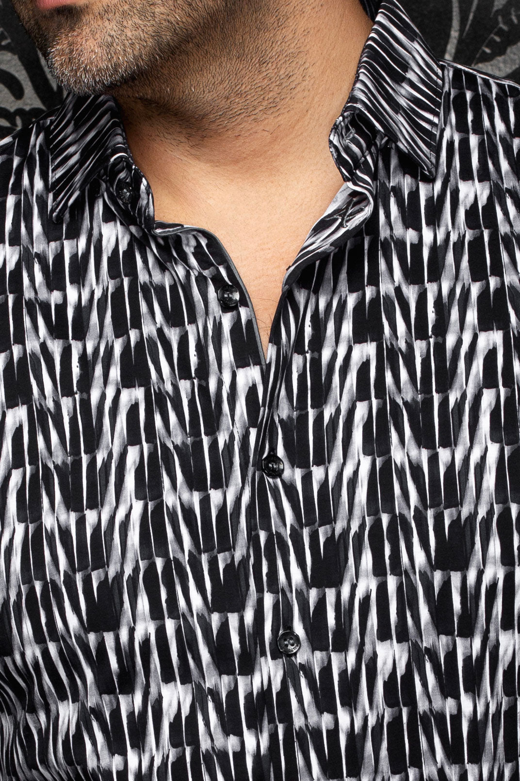 Au Noir men's black and white abstract print shirt shown close-up with black buttons, placket and spread collar