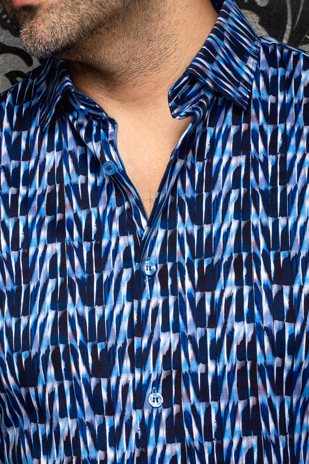 Au Noir men's blue abstract print button-up shirt shown close-up with blue buttons and spread collar