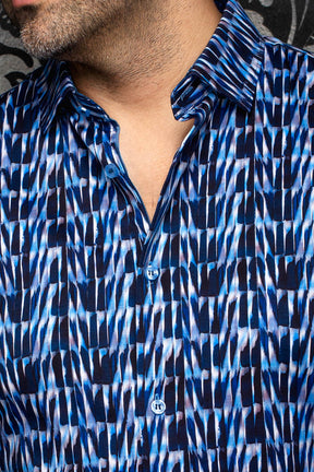 Au Noir men's blue abstract print button-up shirt shown close-up with blue buttons and spread collar