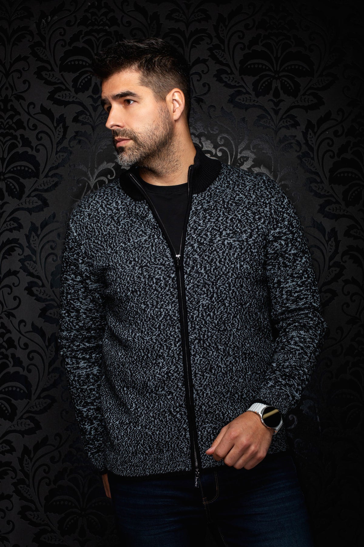 Sur mannequin de face, la veste en cachemire zippée en tricot noir et gris pâle avec col montant pour homme par Au Noir