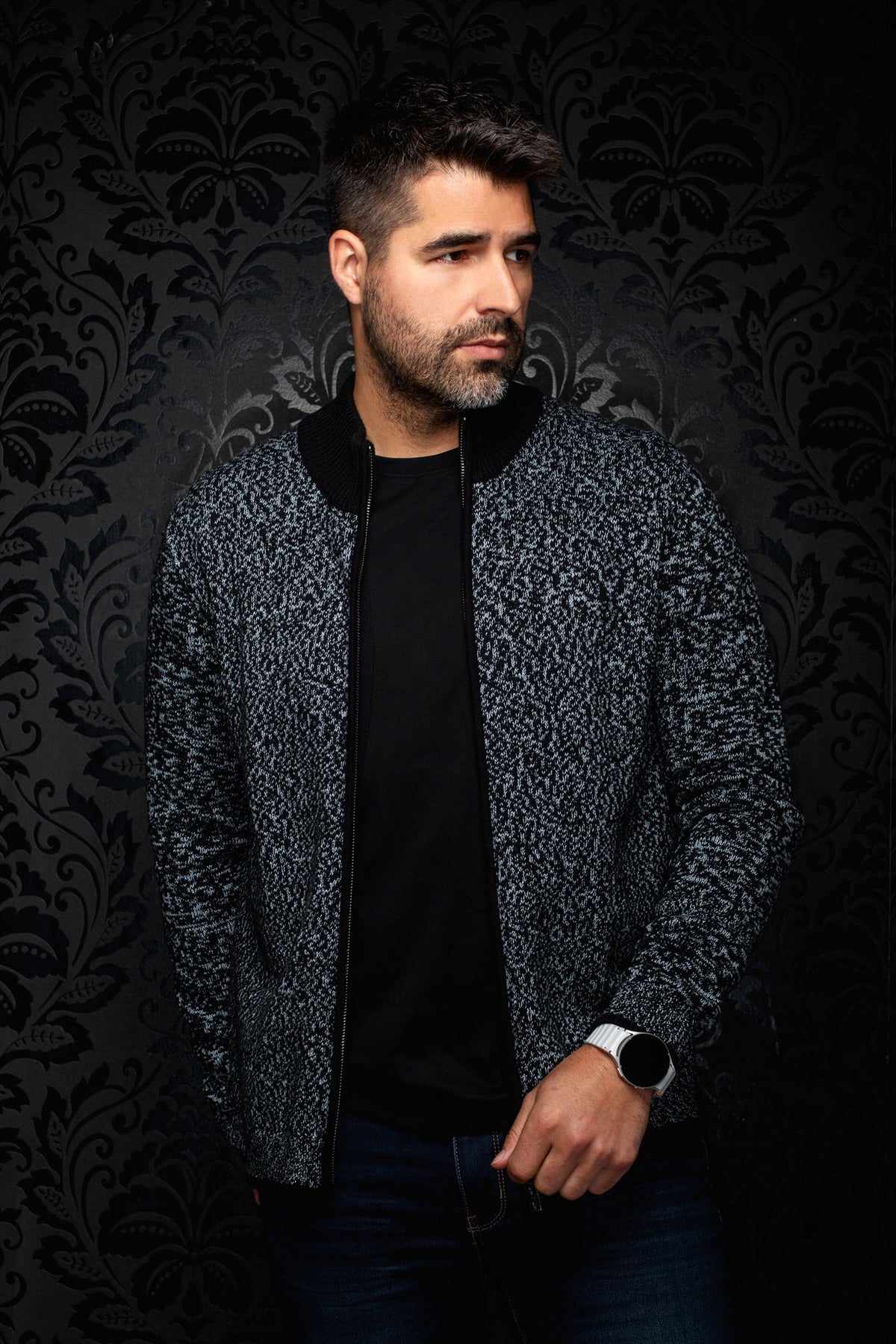 Vue de face sur modèle d’une veste en cachemire zippée en tricot noir et gris pâle à col côtelé noir pour homme par Au Noir