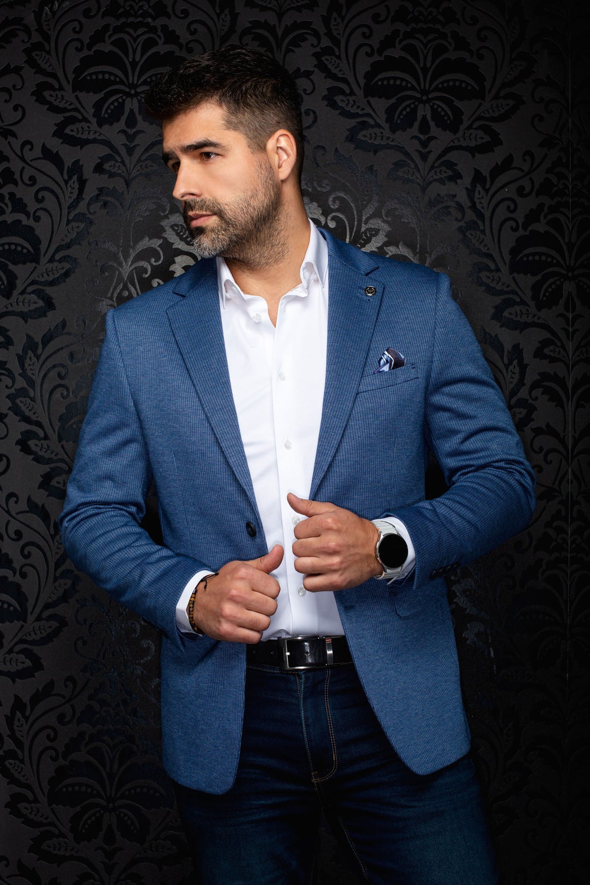 Veston bleu texturé avec revers crantés, épinglette et pochette pour homme par Au Noir, vue de face en angle