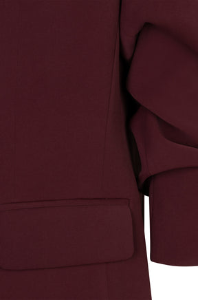 Women's detail of burgundy blazer showing flap pocket, vertical seam and ruched sleeve by Esqualo