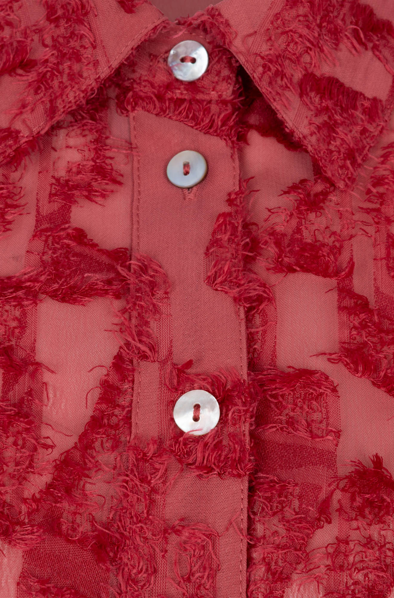 Esqualo women's detail of red long-sleeve blouse collar, pearl-like buttons, and raised fringed abstract texture