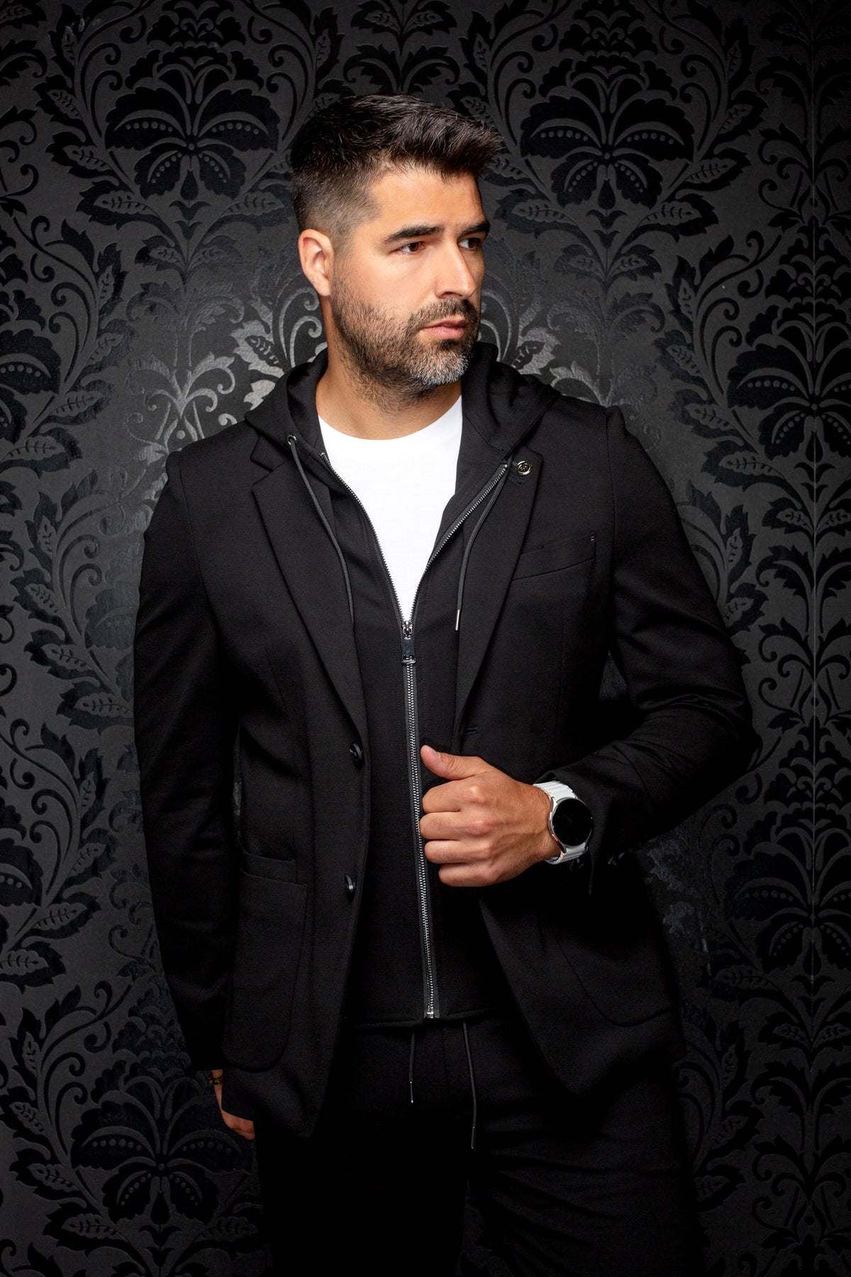 Veston noir de face avec poches avant, revers crantés, cordons et insert zippé pour homme par Au Noir
