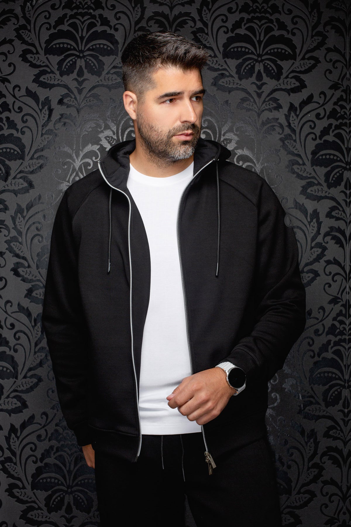 Au Noir men's black hooded zip sport jacket worn open with long drawstrings and silver zipper shown from the front