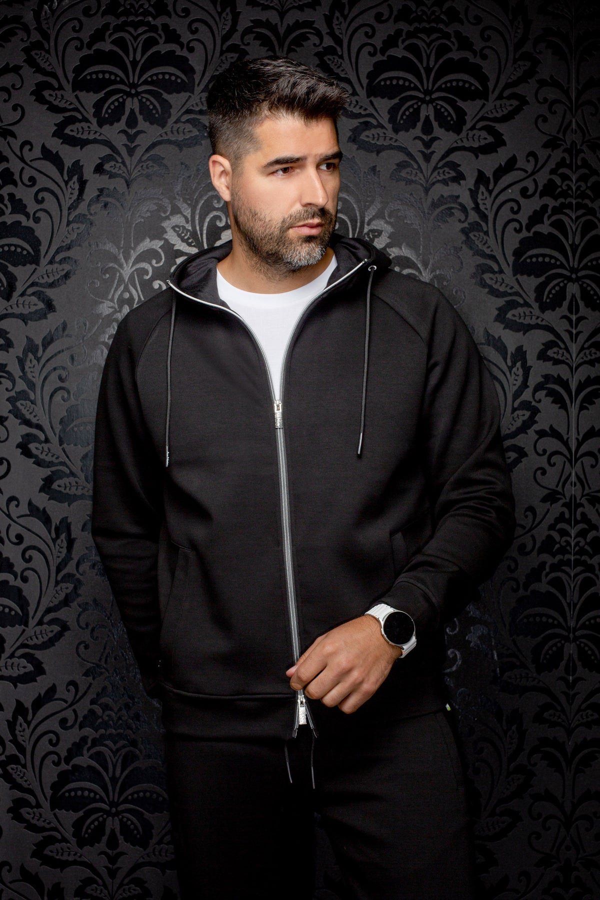 Au Noir men's black hooded zip sport jacket with hand pockets, drawstrings and silver zipper, front model view