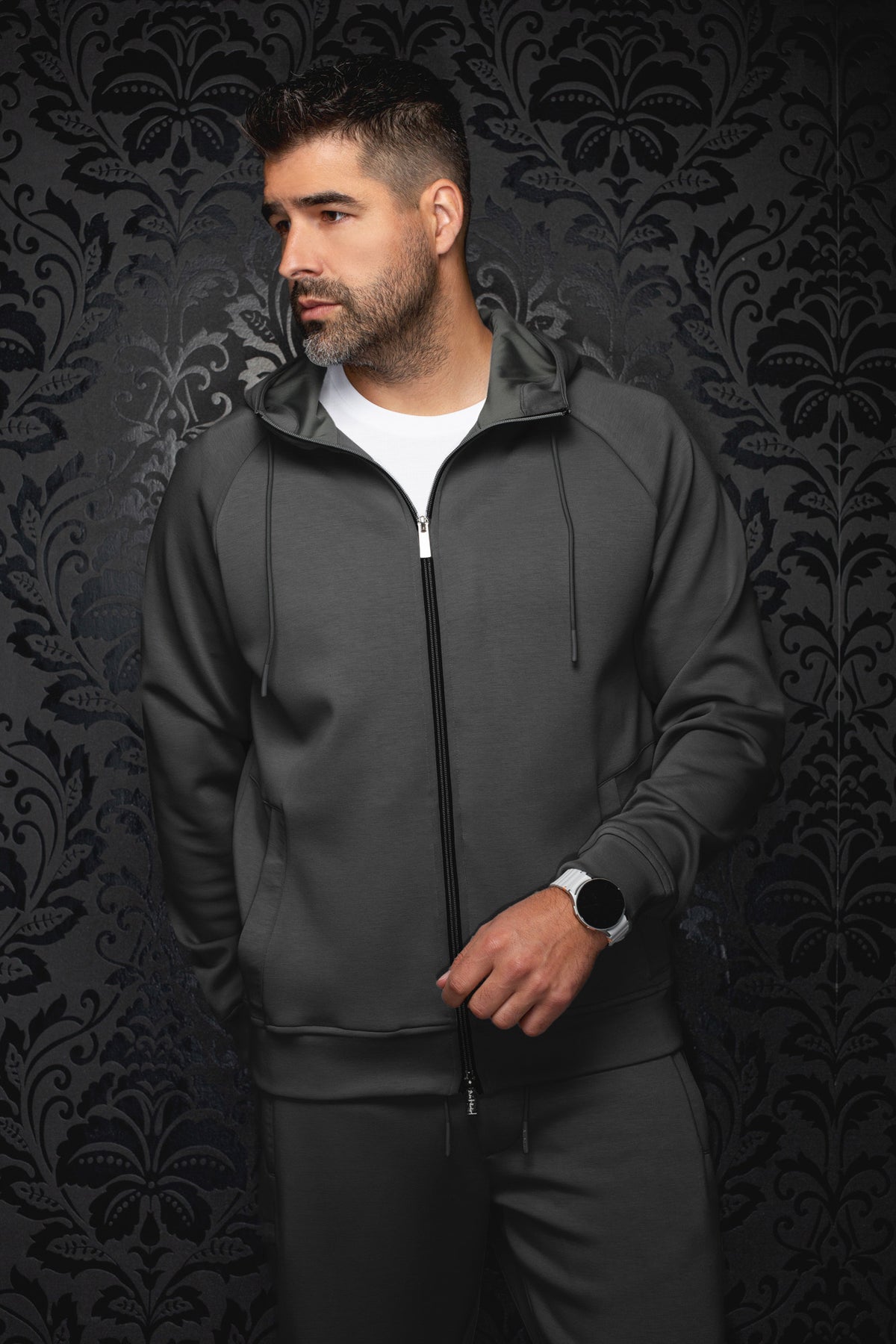 Au Noir men's dark gray hooded zip sport jacket on model, front view with banded hem, drawcords and black zipper