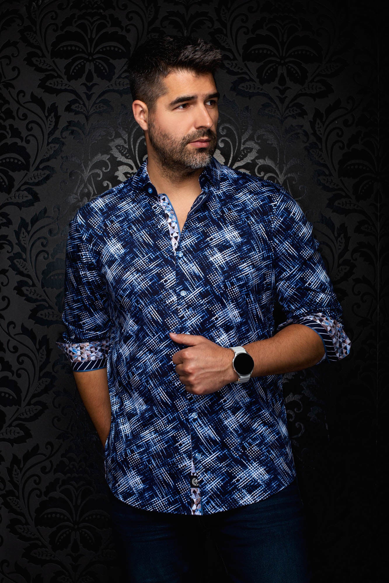 Men's angled front view of a navy patterned shirt with contrast cuff facing and rolled cuffs by Au Noir