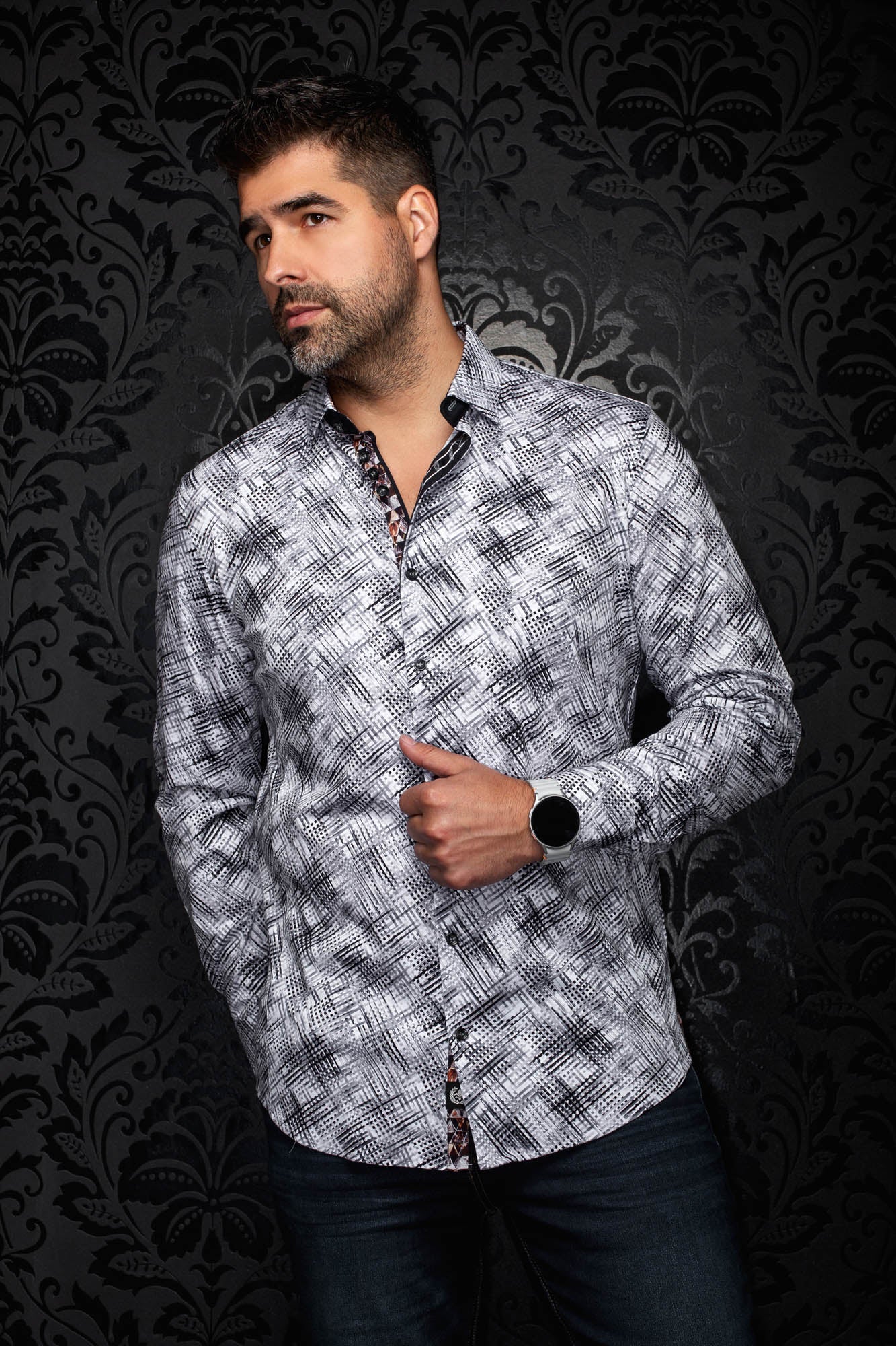 Men's angled front view of white and black patterned button-up shirt with curved hem and long sleeves by Au Noir