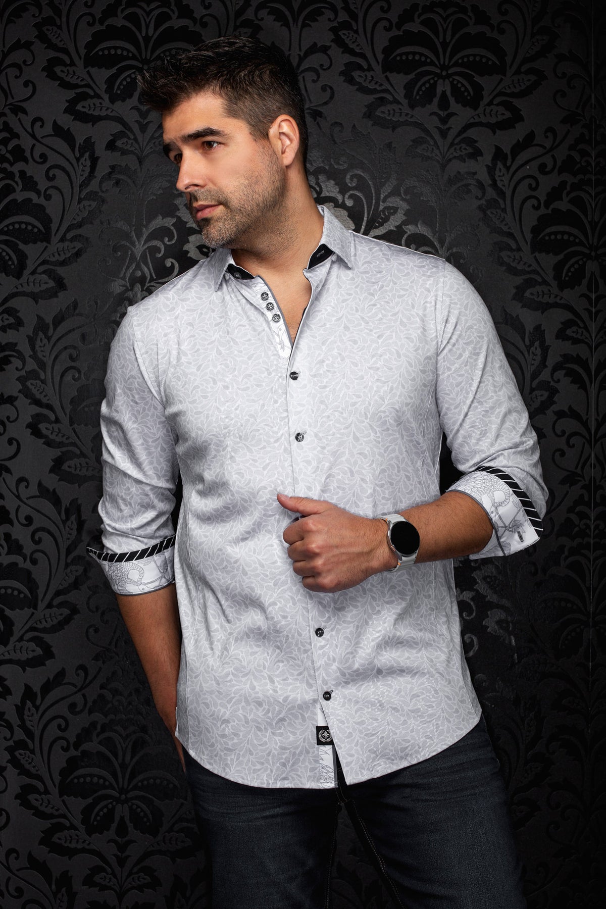 Vue de cote, vue de biais d’une chemise grise pâle à motif floral, poignets roulés et garniture noire pour homme par Au Noir