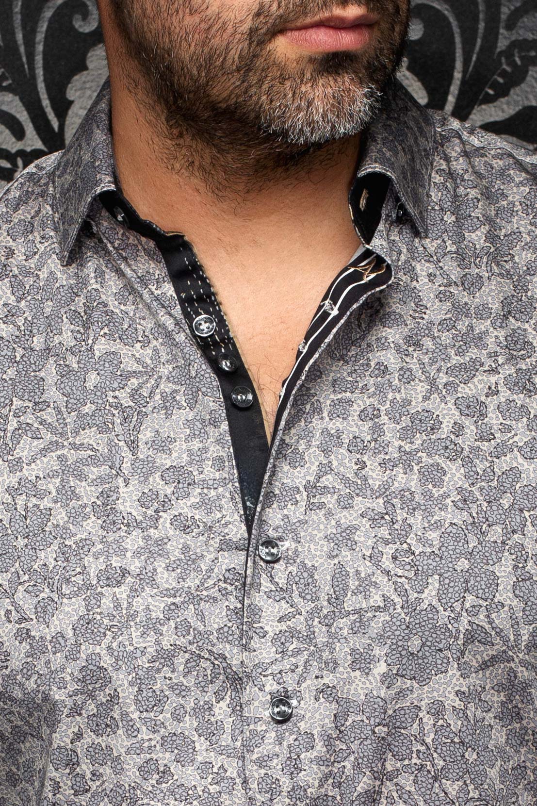 Gros plan du col de chemise grise à fleurs avec boutons et patte noire contrastante pour homme par Au Noir