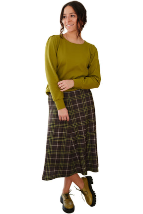 Women's angled front view of a brown plaid midi skirt with olive lines and smooth waist by Rien ne se perd, tout se crée