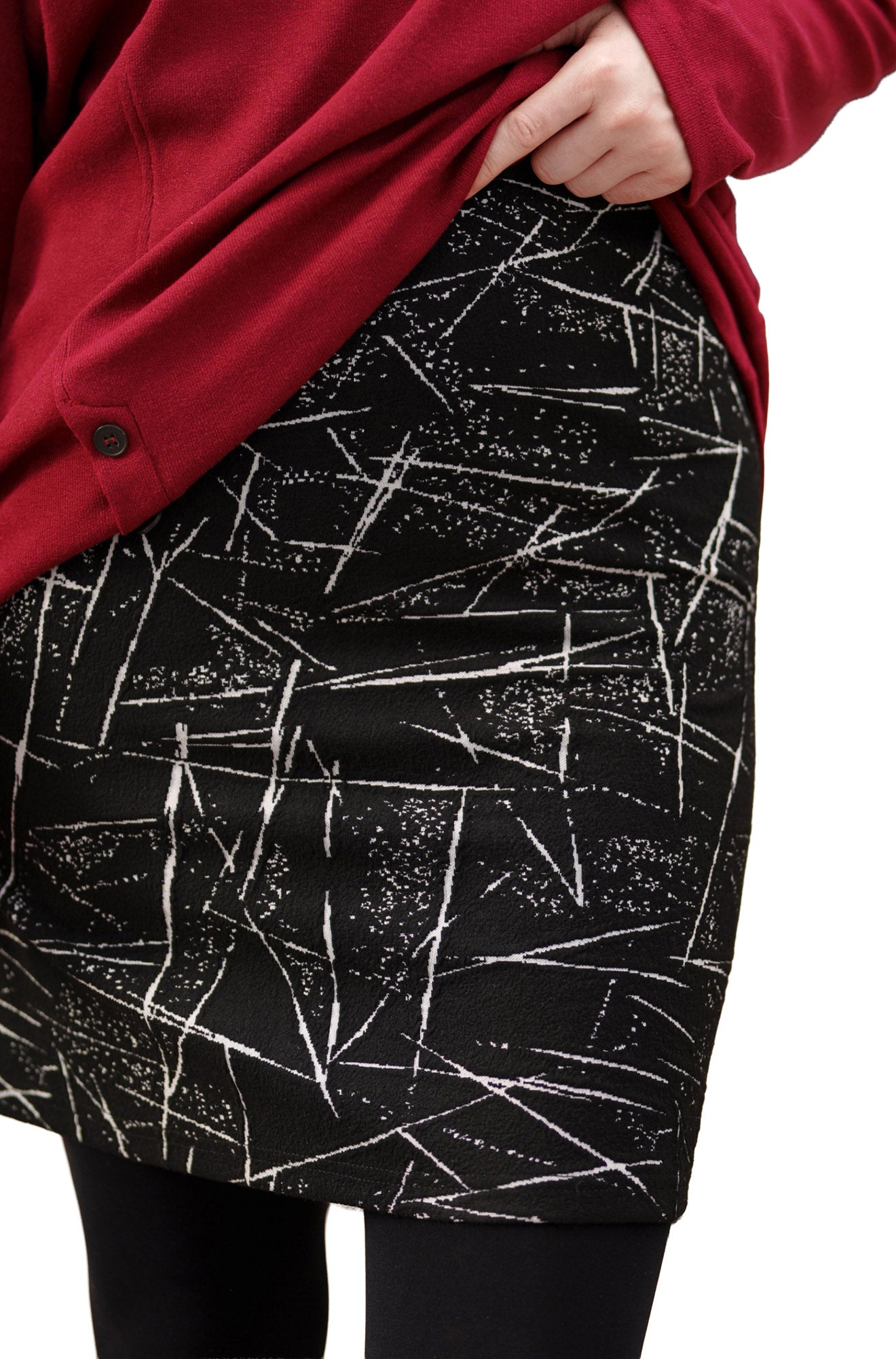 Women's close side view of a black mini skirt with white abstract line print by Rien ne se perd, tout se crée