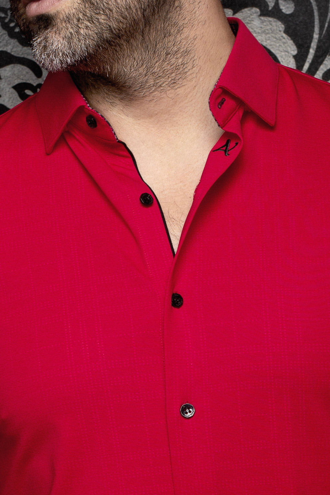 Close-up of men's red button-up shirt collar with small A embroidery, black trim and black buttons by Au Noir