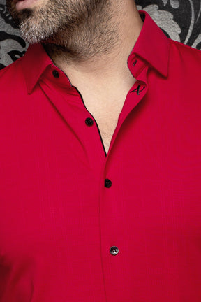 Close-up of men's red button-up shirt collar with small A embroidery, black trim and black buttons by Au Noir