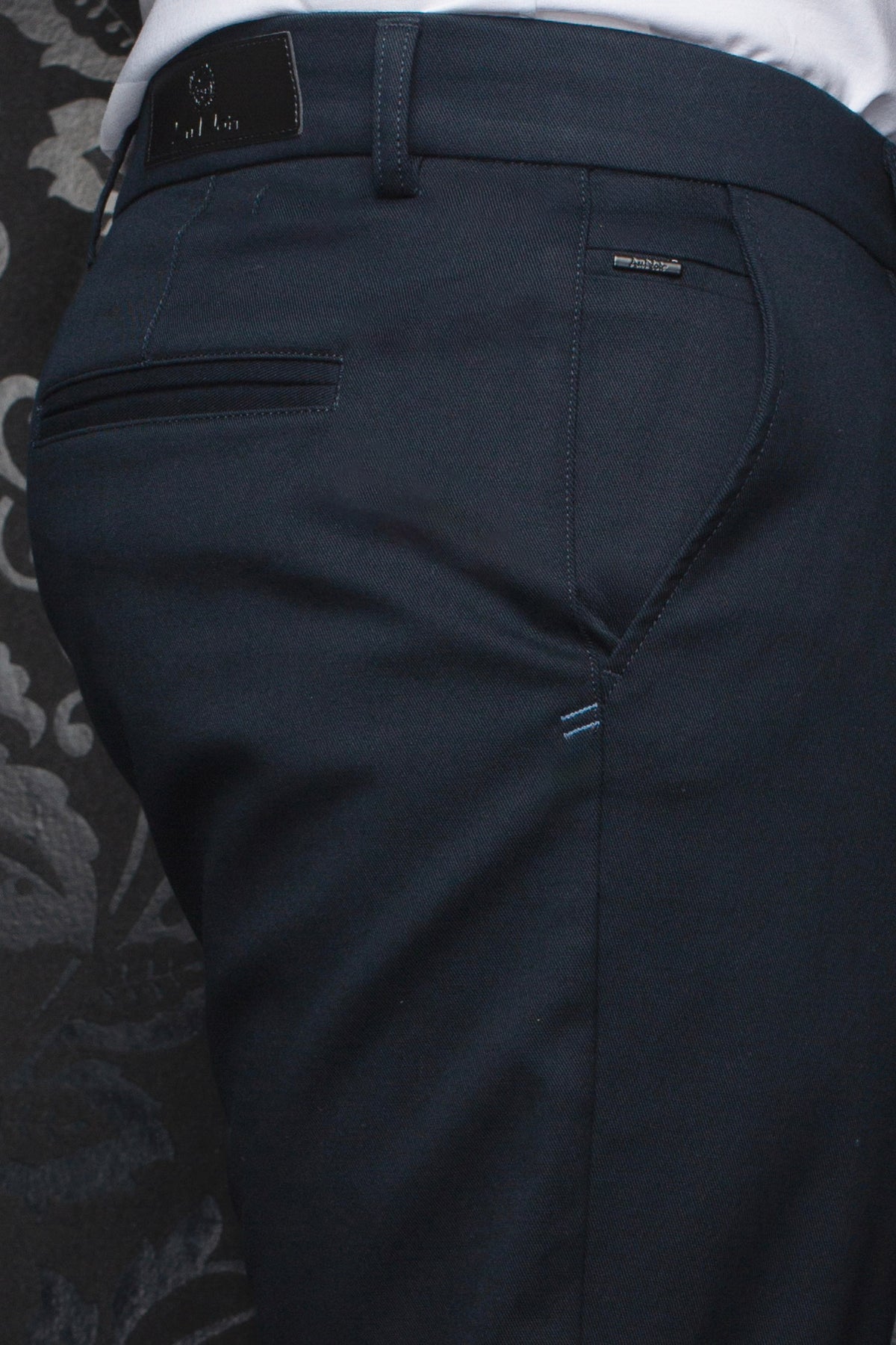 Gros plan du pantalon chino bleu marine avec écusson, poches passepoilées et dos d’un chino pour homme par Au Noir